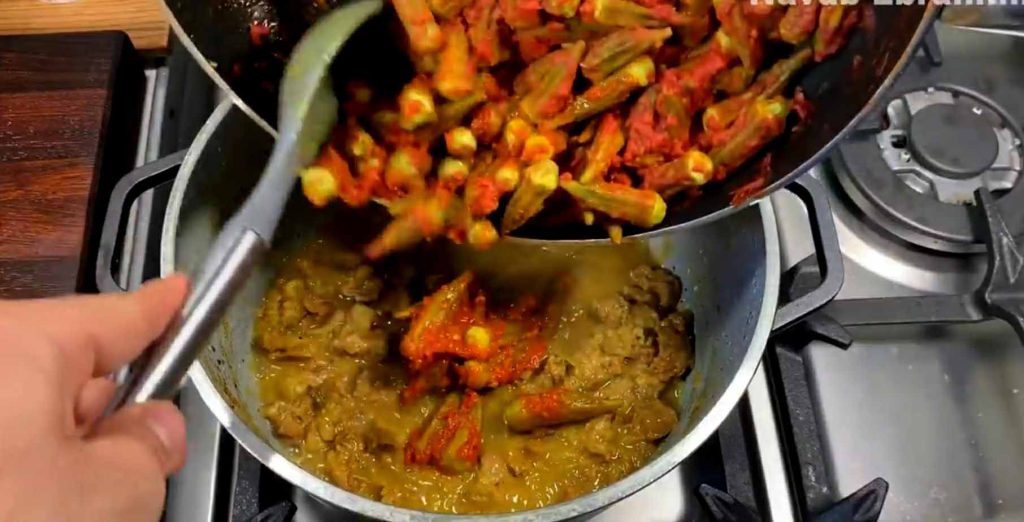 Sautéing okra pods in oil to seal texture and prevent sliminess in stew