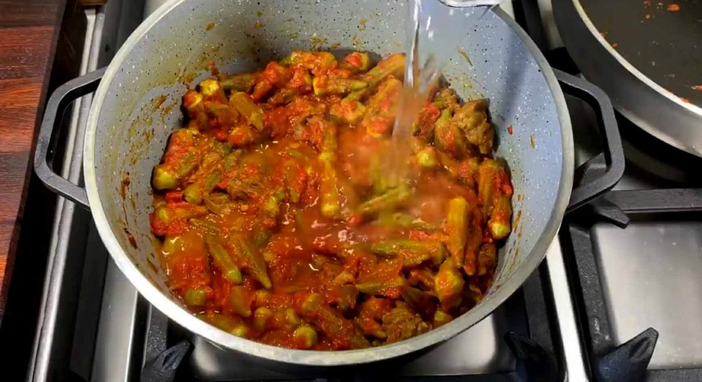 Simmering Persian Okra Stew on low heat until thick and oily (Ja-oftadan)