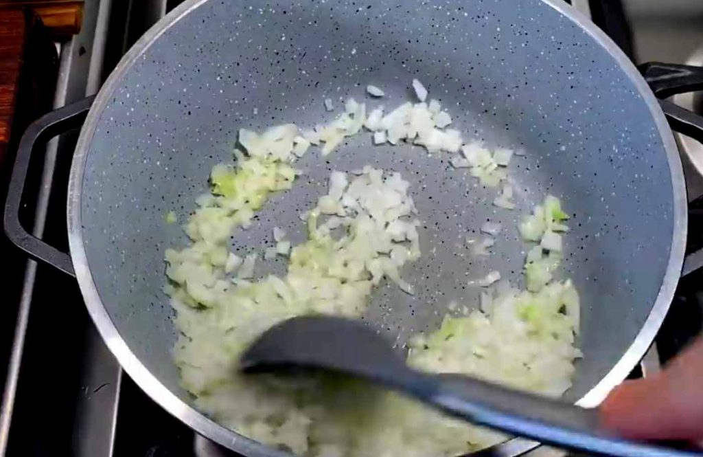 Sautéing onions in a pot until golden and translucent for Okra Stew