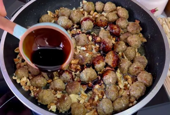 add pomegranate paste to the pan and mix with meatballs
