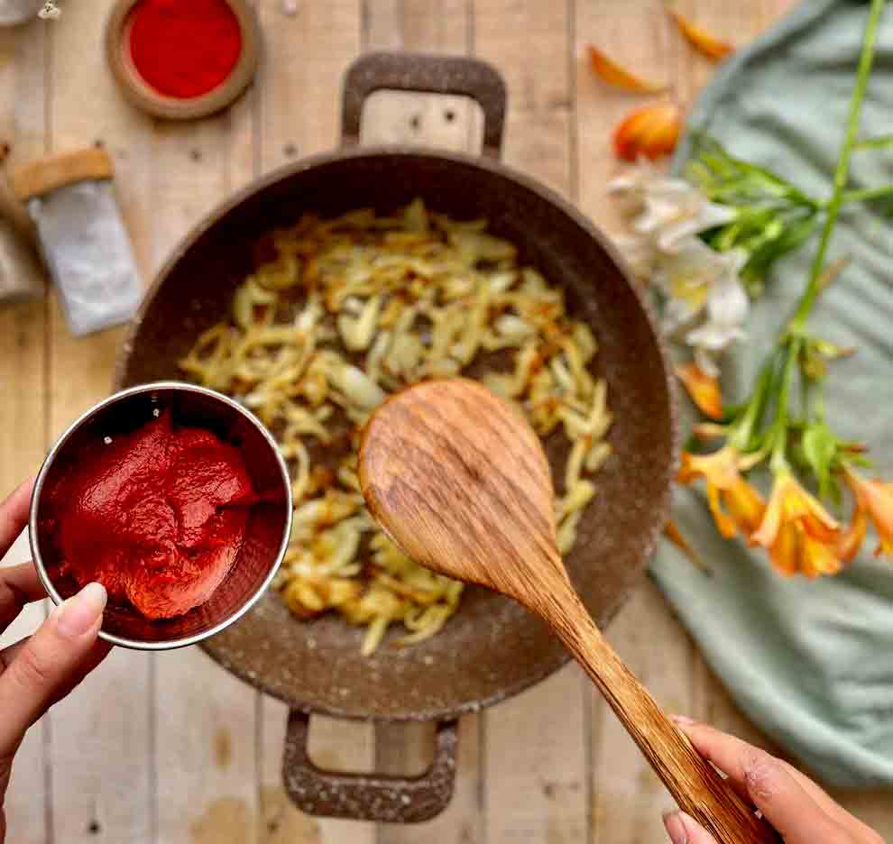 adding tomato paste for dopiazeh meygoo