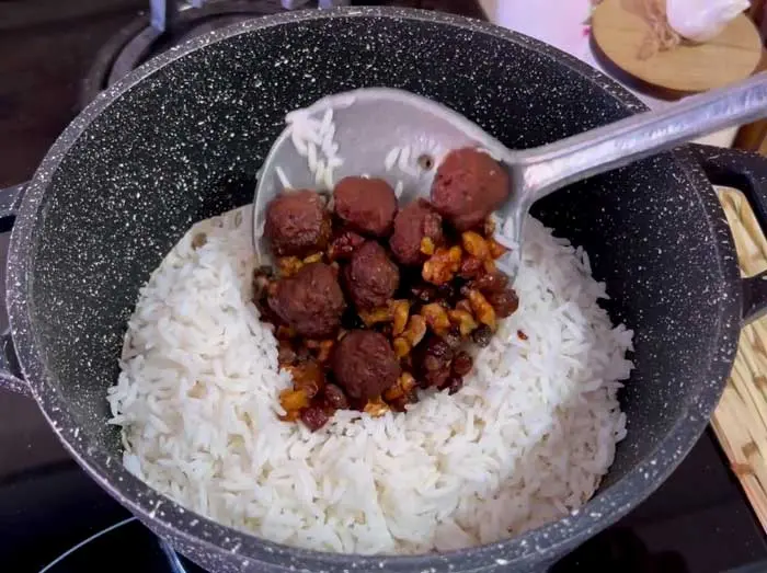 Pour layer of meatballs to rice