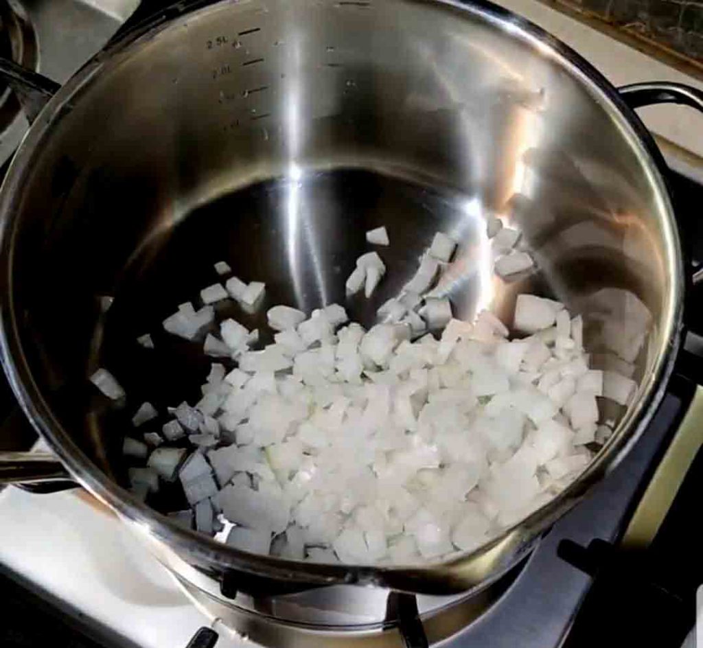 chop the onion to prepare khoresht kadoo halvaei