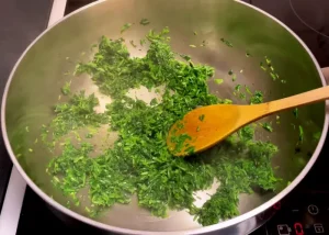 sautéing the herbs for ghalieh mahi