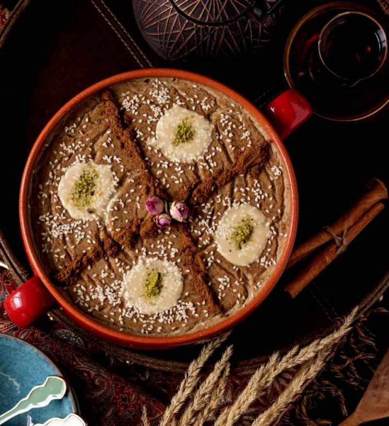 Iranian Haleem with wheat and meat, garnished with cinnamon and sesame