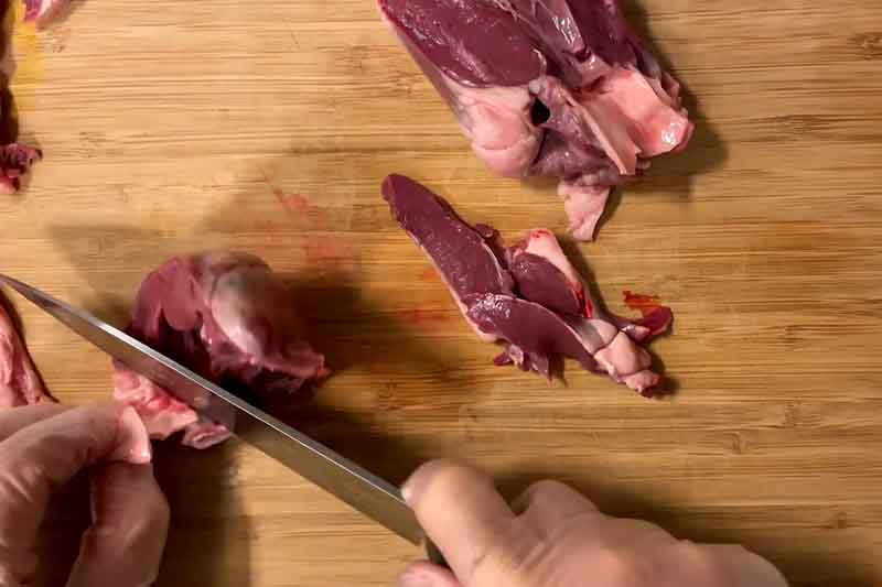Chopped lamb liver and heart on a wooden cutting board for Jaghoor Baghoor preparation