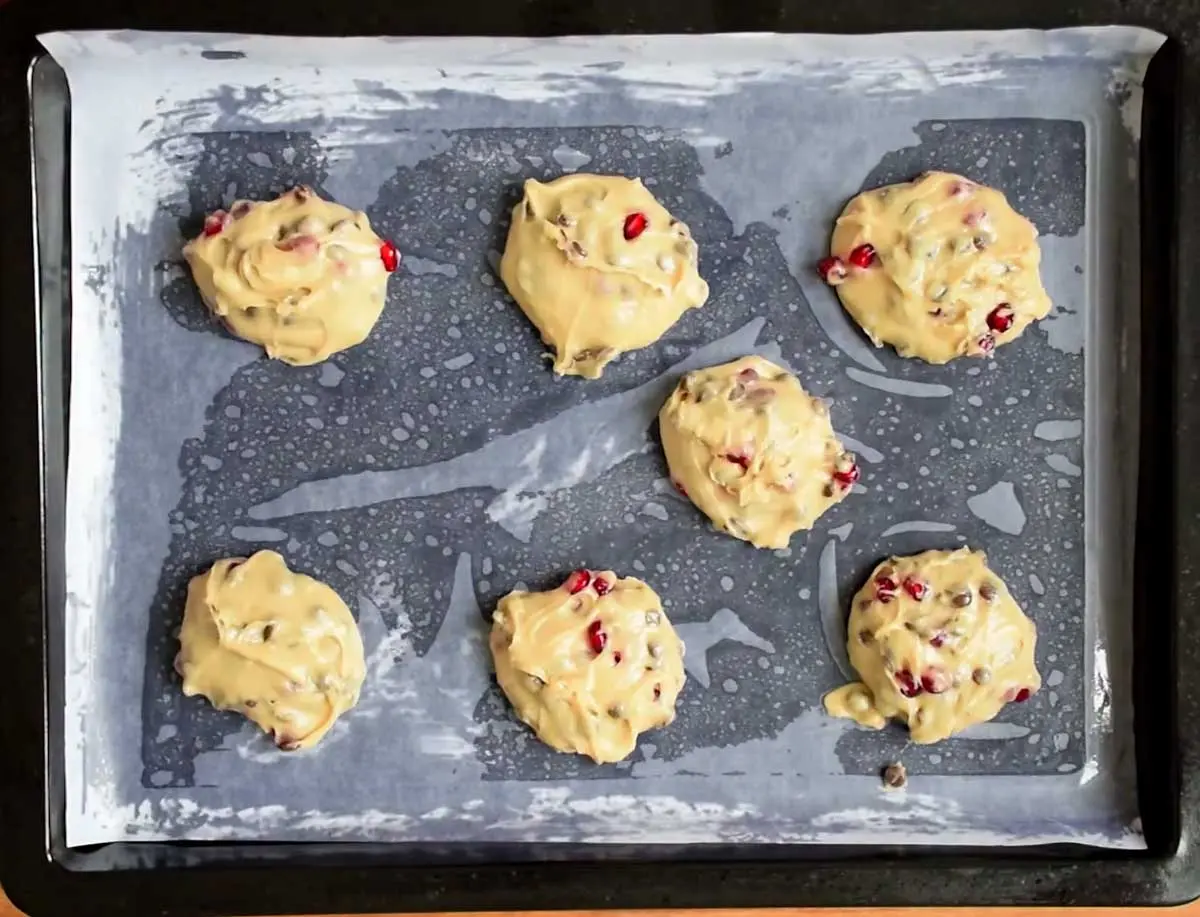 Placing pomegranate cookies on a baking tray for baking in the oven